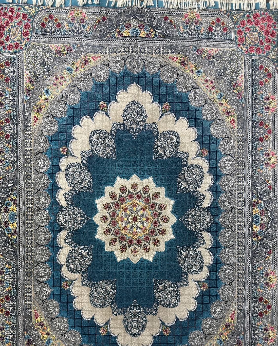 A 700 reed Persian rug on the showroom floor, a deep blue field under a cream and rose medallion